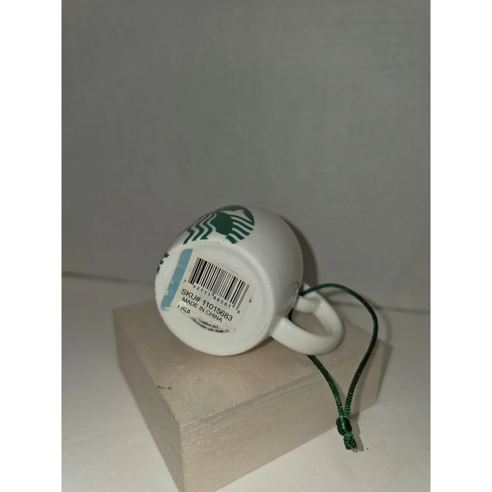 white‎ ceramic Starbucks ornament featuring a green siren logo